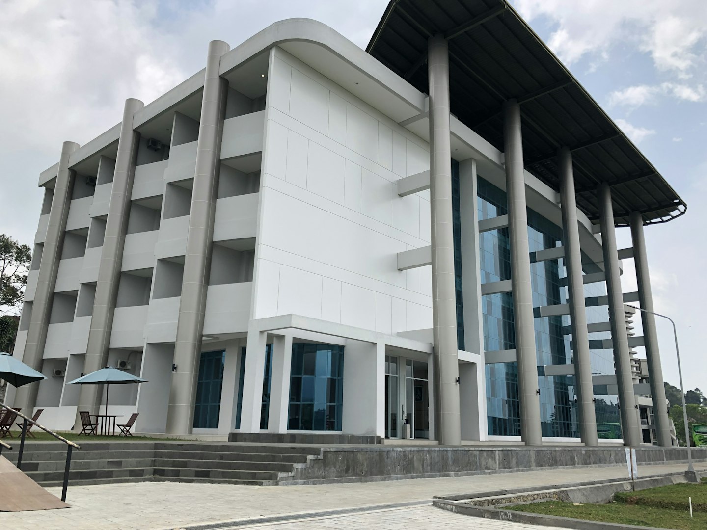 Modern commercial building exterior with clean architectural columns and large windows, showcasing new construction block and brick work.